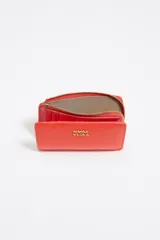 Billetera plateada de piel con textura tipo escamas, cierre de cremallera y logo metálico de la marca Bimba y Lola.