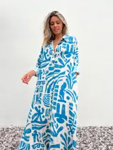 Vestido camisero largo de corte amplio, con estampado abstracto en tonos celeste y crudo.