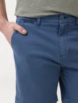 Short de gabardina azul con bolsillos delanteros y traseros, tiro medio y ajuste con broche y cierre.