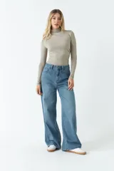 Body negro de poliéster y spandex, con cuello alto tipo polera, mangas largas y frunces laterales.