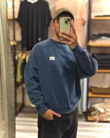 Buzo azul con efecto nevado gastado, corte oversized y cuello redondo.