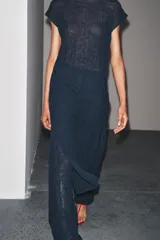 Vestido midi azul marino semitransparente de punto fino con efecto arrugado, cuello redondo, manga corta y aberturas laterales en el bajo. Cierre en la espalda con lazo.