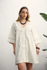 Vestido corto color beige con cuello en V y mangas 3/4 con ribete marrón.