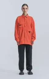Camisa naranja de manga larga, estilo técnica con múltiples bolsillos delanteros y un bolsillo en la parte inferior de espalda, botones en cartera y mangas, calce oversize.