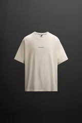 Camiseta color crudo de corte relaxed fit, cuello redondo y manga corta. Estampado con la frase "Speed Run Progress" en el frente y texto en la espalda.