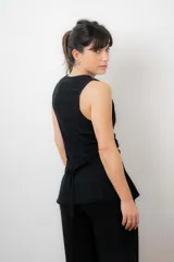 Chaleco sastrero color crudo, con escote en V y cierre frontal con botones.