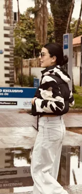 Campera puffer cropped negra con mangas y capucha de polar estampado con diseño geométrico en tonos beige, marrón y negro.