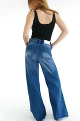 Pantalón de jean azul de corte wide leg con terminación desflecada.