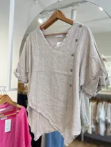Blusa beige de lino con cuello en V y cierre lateral con botones de madera.