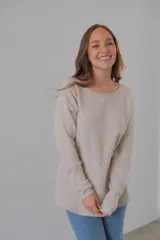 Sweater color beige de punto con cuello redondo y corte recto.