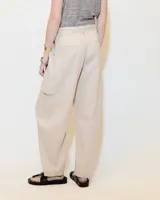 Pantalón de lino color gris gastado, con pinzas, silueta comba en piernas, bolsillos ojal en pierna izquierda y espalda. Largo hasta los tobillos y tiro medio.