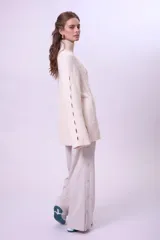 Pantalón de vestir color beige, de corte palazzo y tiro alto, con cierre lateral con botón y cremallera.