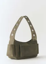 Bolso de hombro color verde oliva, de tamaño mediano, confeccionado en cuero vacuno. Presenta cierre metálico con imán, asa de hombro fija, bolsillos laterales y tachuelas decorativas.