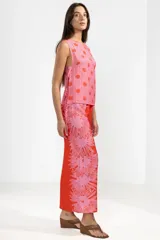 Pantalón palazzo de viscosa color rojo con estampado de girasoles rosas, cintura elastizada y corte amplio.