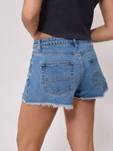 Short de jean negro con roturas y terminaciones desflecadas.