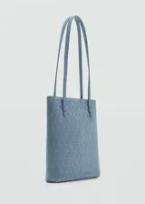 Bolso tipo tote de cuero color celeste con perforaciones circulares. Tiene doble asa corta y bolsillo interno.