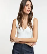 Blusa blanca de punto acanalado, sin mangas y con escote en pico.