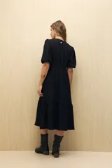 Vestido midi color marrón claro, con escote en V, mangas cortas abullonadas, botones frontales y falda con volantes.