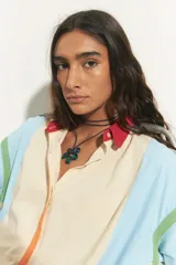 Collar con cordón negro y dije de flor azul de acrílico.