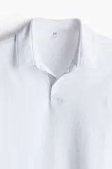 Remera polo blanca de punto de algodón liviano, corte slim fit, con cuello, tapeta de botones y bajo recto.