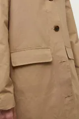 Abrigo tipo trench largo color beige, con cuello de contraste en material oscuro (posiblemente cuero o efecto cuero). Presenta cierre frontal con botones y corte recto.