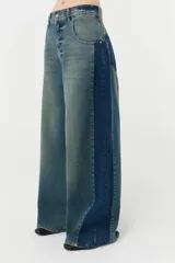 Jean wide leg de denim 100% algodón con recortes laterales de un lavado más oscuro y bolsillos traseros y relojero con ese mismo lavado. Tiene un lavado localizado sobre tono color efecto vintage en frente y espalda.