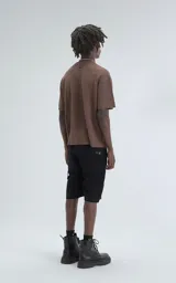 Remera de tejido de punto color café, con mangas cortas y cuello redondo. Presenta una textura calada y un calce ligeramente oversize.