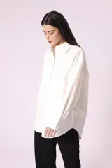 Camisa celeste de corte amplio, con cuello clásico, cierre frontal con botones y bolsillo en el pecho.