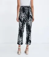 Pantalón pijama fluido de viscosa con estampa geométrica en blanco y negro. Tiene cintura media con ajuste de cordón con puntera metálica, bolsillos y prega frontal.