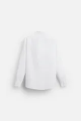 Camisa blanca de corte regular, cuello italiano, manga larga con puños abotonados y cierre frontal con botones.