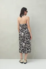Vestido midi con estampado de hojas, escote halter y falda acampanada.