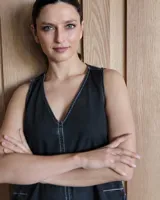 Vestido largo color crudo, sin mangas y con escote en V. Presenta aberturas laterales en el ruedo y bolsillos laterales a la altura de la cadera.