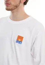 Remera blanca de manga larga confeccionada en algodón. Estampa cuadrada en el pecho con un paisaje de atardecer.
