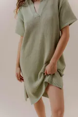 Vestido tejido color verde claro, con escote en V, mangas cortas y aberturas laterales.