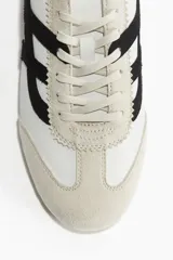 Zapatillas deportivas H&M color blanco con detalles en negro y beige. Confeccionadas en cuero sintético y gamuza, con cordones y suela de goma.