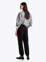 Joggers negros de felpa de mezcla de algodón con pierna cónica, cintura elástica con cordón, dos bolsillos laterales ribeteados y logo de Tommy Hilfiger bordado en el muslo.