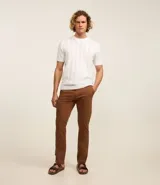 Pantalón de vestir color marrón, de corte recto, con bolsillos laterales y traseros. Se ajusta a la cintura con cinturón de cuero marrón.