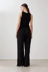 Pantalón verde oliva de corte palazzo con pretina elastizada y cordón ajustable. Incluye bolsillos laterales.