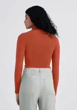 Blusa de tejido de punto color ladrillo, con cuello alto y mangas largas.