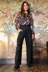 Pantalón de tiro alto color negro, con cintura plegada, pinzas, bolsillos laterales y corte palazzo.