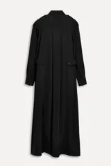 Vestido largo negro tipo camisero, confeccionado en viscosa. Tiene cuello solapa, manga larga con puños, bolsillos delanteros y cierre frontal con botones. Incluye cinturón ajustable con trabillas y botones.