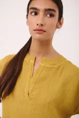 Vestido corto de lino color vino tinto, con escote en V y mangas cortas tipo musculosa. Presenta un corte holgado con volados en el ruedo.