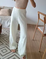 Conjunto de sweater y pantalón de punto color crema con diseño trenzado.