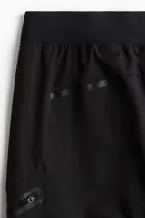 Pantalón de jogging deportivo negro de corte ajustado, confeccionado en tejido funcional DryMove™ que ayuda a absorber el sudor. Cuenta con cintura elástica con cordón de ajuste, bolsillos laterales, bolsillos con cierre en las piernas y bajos con elástico revestido.