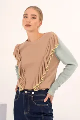 Sweater de punto con volados en el frente, color camel con mangas en color verde claro, de manga larga y suavemente abullonada.