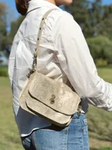 Bandolera dorada con glitter, de tamaño pequeño, con correa larga regulable y cierre con broche metálico.