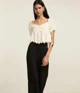 Pantalón negro de vestir, corte wide leg, cintura alta con doble pretina y detalle de remaches.