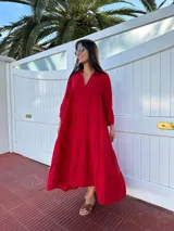 Vestido largo rojo de lino, con cuello mao y escote en V. Tiene corte amplio, mangas 3/4 con volados y diseño escalonado.