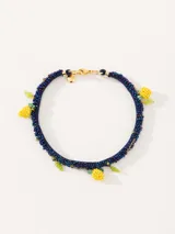 Collar corto con cordón azul bordado con mostacillas de vidrio y dijes de limones amarillos y hojas verdes bordados a mano con mostacillas.