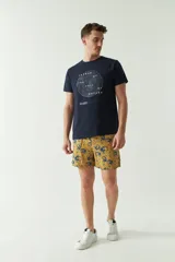 Short de baño celeste con estampado de hojas, cintura elástica con cordón ajustable, dos bolsillos laterales y uno trasero.